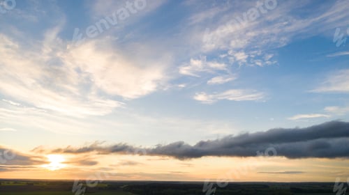 Preview: Green meadow under a blue sunset sky with clouds