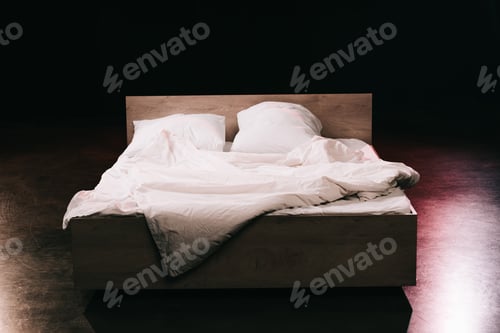 Preview: soft pillows on white clean bed sheets in bedroom on black