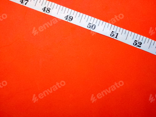 Preview: Selective focus.Measuring tape on a red background