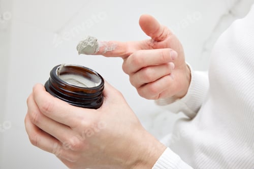 Preview: Woman Holding Clay Mask in Jar at Home