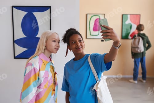 Preview: Two teenage girls taking selfie photo in art gallery