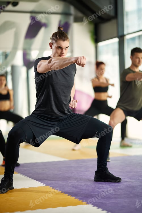 Preview: Full length of athletic man practicing martial arts while working out at health club.