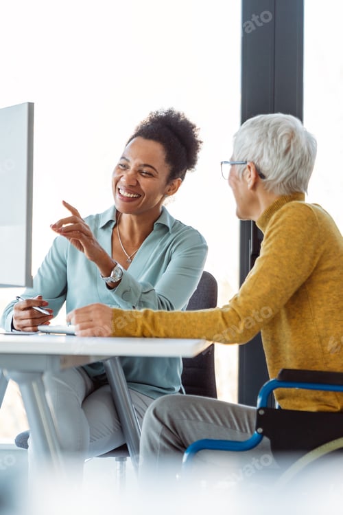 Preview: Mentorship and diversity in a modern office as colleagues share a laptop for team collaboration
