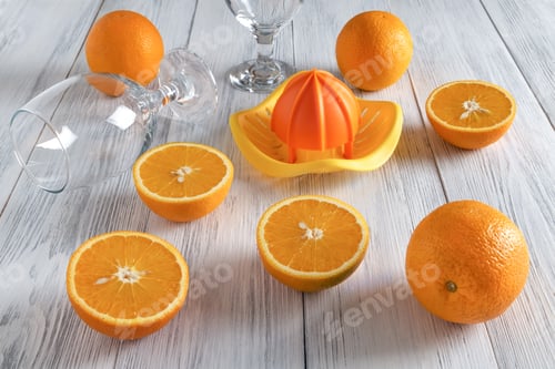 Preview: Whole and cut in half, ripe oranges and fresh juicing tools