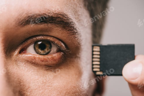 Preview: cropped view of man holding microchip near head