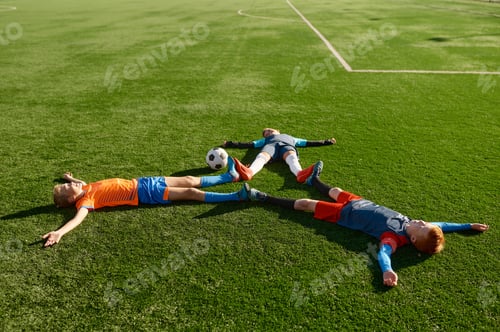 Vorschau: Glücklicher müder Fußballspieler liegt wie ein Stern auf der grünen Wiese