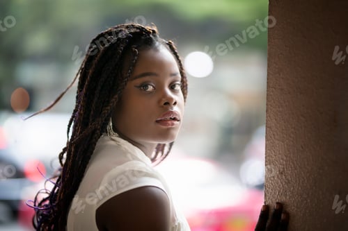 Preview: Portrait of a happy afro American woman standing on street.