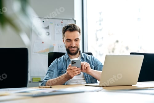 Preview: Positive caucasian man, freelancer, programmer, seo, sits at a table in the office, uses a