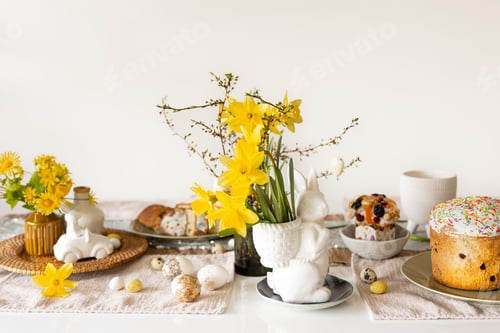 Preview: Easter holiday table with eggs, traditional pastries and flowers daffodils.