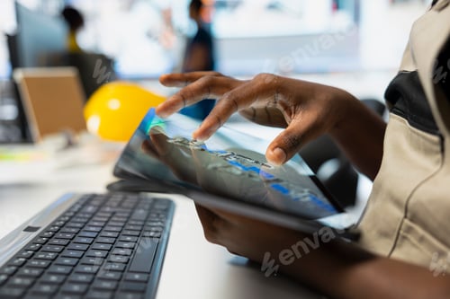 Preview: African american supervisor manages data from solar machinery on tablet