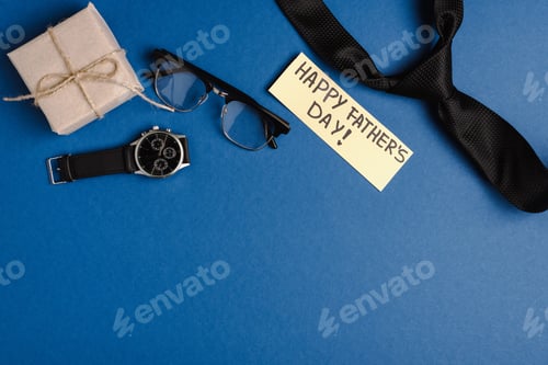 Preview: Top view of gift box, greeting card with lettering happy fathers day and mens black tie, wristwatch