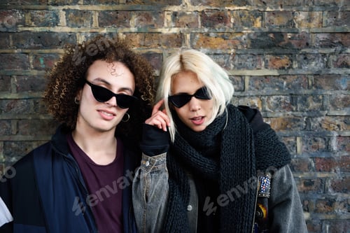 Preview: Young couple enjoying Camden town in front of a brick wall typical of London