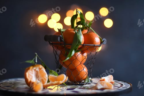 Preview: bucket with bright orange tangerines on yellow bokeh background,christmas mood,winter holiday spirit