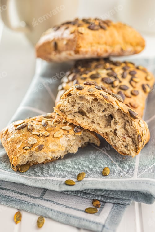 Preview: Whole grain bun with pumpkin seeds on napkin.