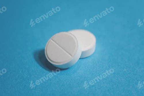 Preview: Close up two white pills on the blue background.