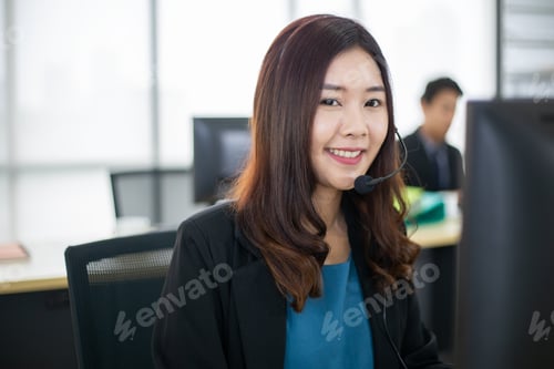 Preview: Asian female call center with headphone talking to customer in the office