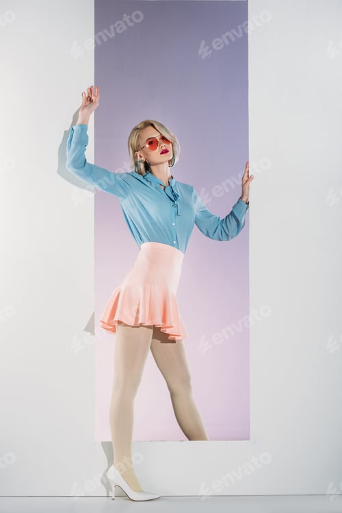 Preview: beautiful stylish young blonde woman posing in aperture on grey
