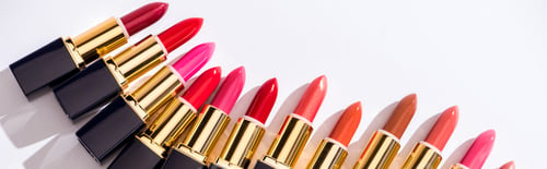 Preview: top view of assorted lipsticks in luxury tubes on white background, panoramic shot
