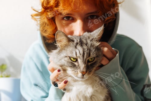 Preview: portrait teenage red-haired girl with fluffy green-eyed cat