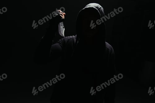 Preview: Silhouette of bandit holding knife isolated on black