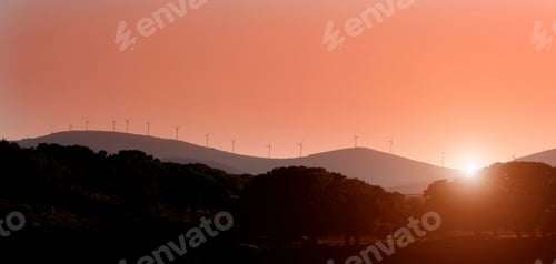 Preview: Silhouette of windmills on rural hills