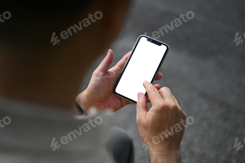 Preview: Over shoulder view of middle age man using mobile phone at outdoor.