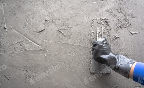 Preview: Hand plasterer plastering cement wall background, hand worker brush rough concrete floor for smooth