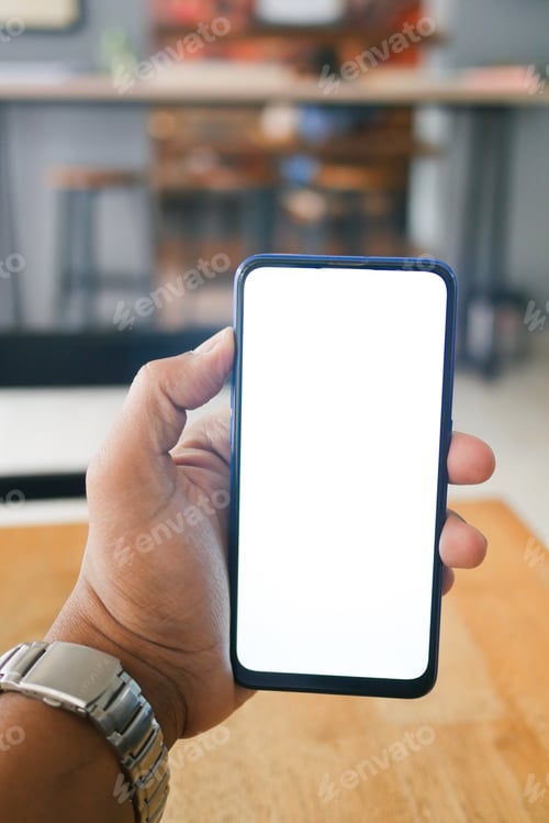 Preview: Close up of young man hand using smart phone with white screen at cafe