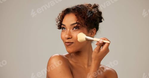 Preview: Woman, studio and smile with makeup brush for foundation and cosmetics application on gray backgrou