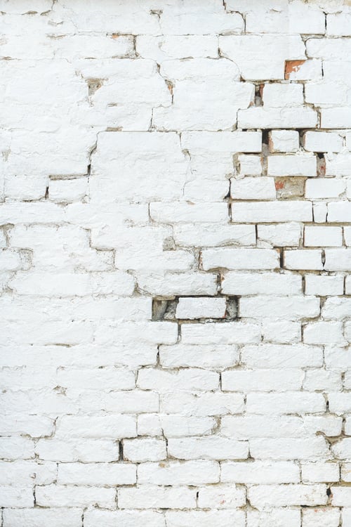 Preview: Old damaged brick wall painted in white color
