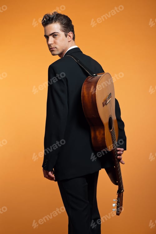 Preview: Retro Country Musician With Guitar On Is Back Wearing Black Suit. Studio Shot.