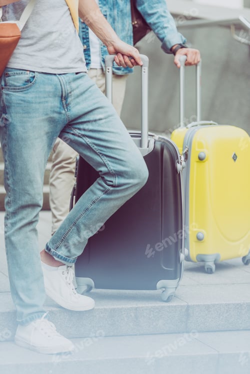 Preview: cropped view of young male tourists with suitcases