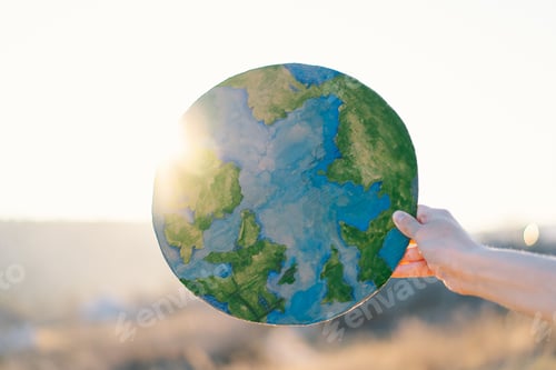 Preview: Woman holding planet in hands against green spring background. Earth day