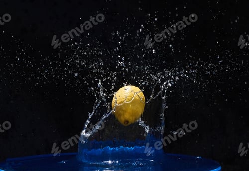 Preview: Yellow lemon falling in the blue water on a black background