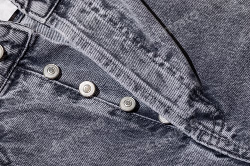 Preview: Unbuttoned gray jeans close-up, metal buttons in a row on denim pants