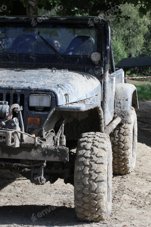 Preview: Vertical closeup of a muddy UAZ car on a rocky road