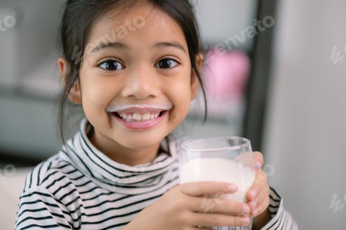 Preview: Asian little cute girl drinking milk Young preschool child girl or daughter stays home