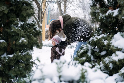 Preview: Woman and Toddler Enjoying Winter Snowfall Outdoors