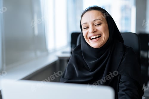 Preview: Beautiful arabian woman with abaya dress working in the office