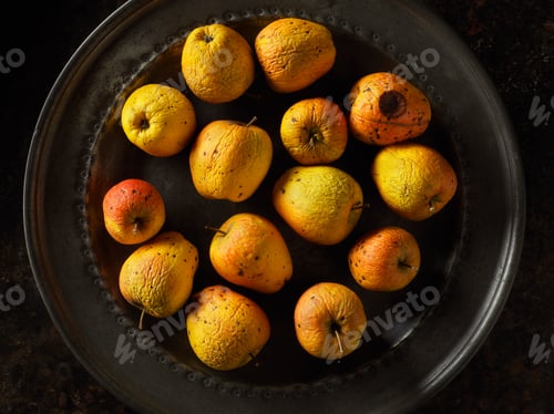 Preview: Overhead view of old red and golden apples on pewter plate
