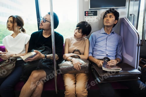 Preview: Four people sitting sidy by side on a subway train, Tokyo commuters.