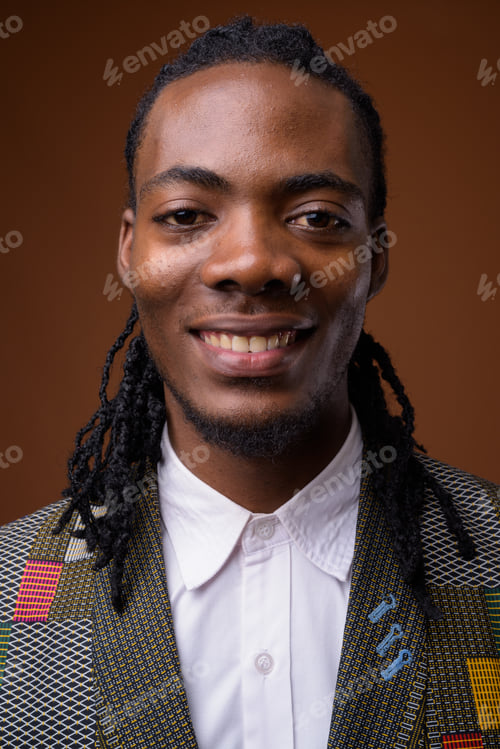 Preview: Young handsome African businessman against brown background