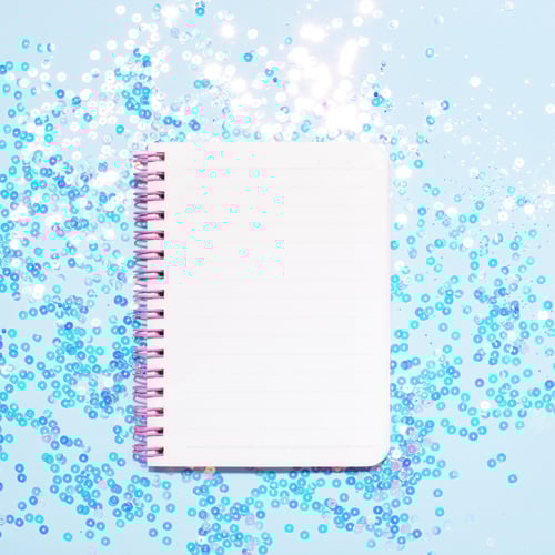 Preview: Top view of white note book page on shining blue background.