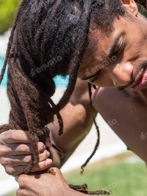 Preview: Close-up of a black man who slips his dreadlocks when he comes out of the pool