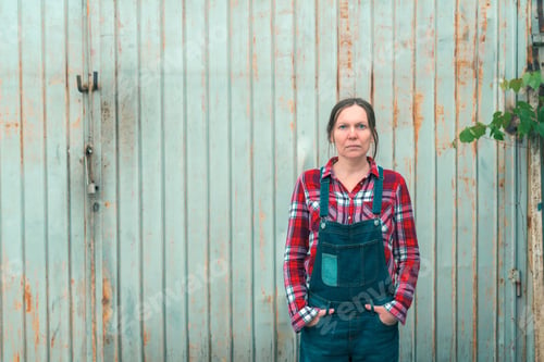 Preview: Portrait of beautiful female farmer in front of farmhouse shed