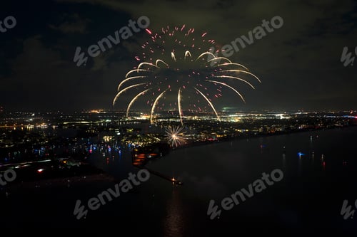Visualização: Vista aérea de fogos de artifício brilhantes explodindo com luzes coloridas sobre a costa do mar