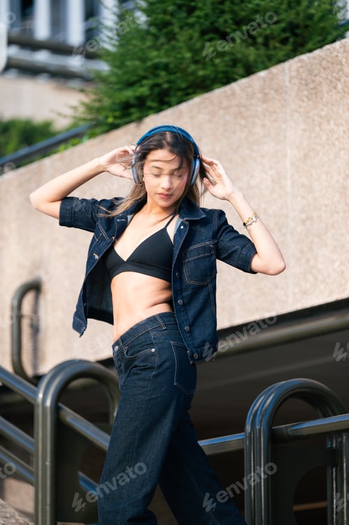 Preview: Young woman enjoying music with headphones in urban lifestyle