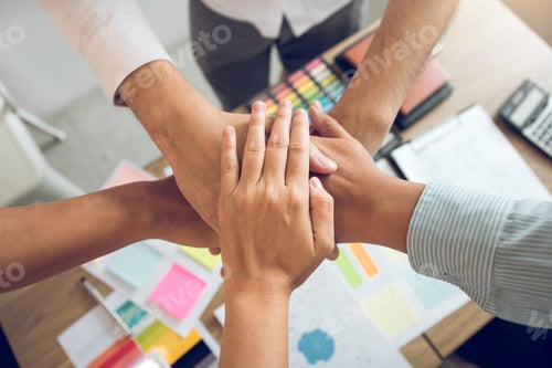 Preview: Close up of group of business people joining their hands together in unity.