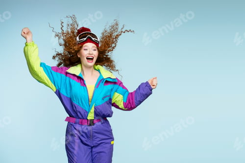 Preview: Excited skier wearing colorful retro outfit is celebrating success