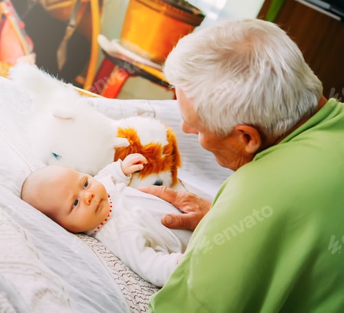 Preview: Grandfather with newborn at home. Senior man is talking with a baby.